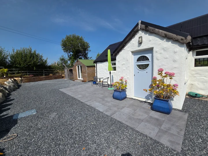 Paving, gravel paths and planted pots around a completed cottage garden