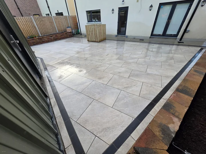 Porcelain paving outside the doors, with a dark border along the patio edge.