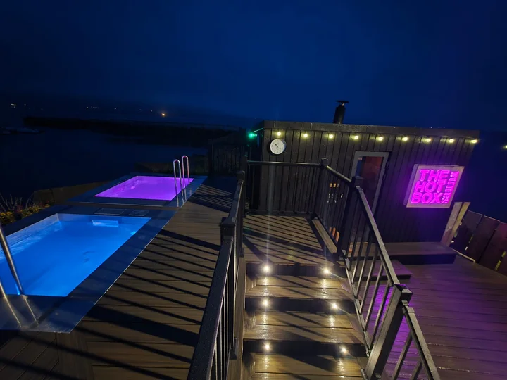 Coloured pool lighting beside the deck and balustrades.