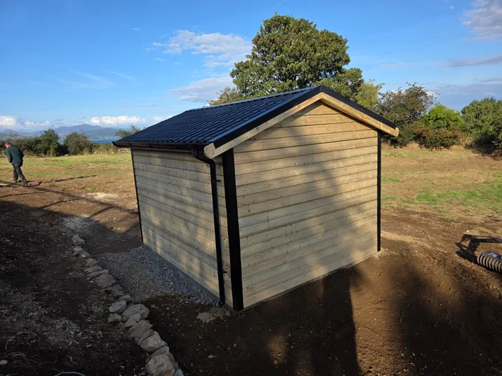 The timber outbuilding from the rear corner.