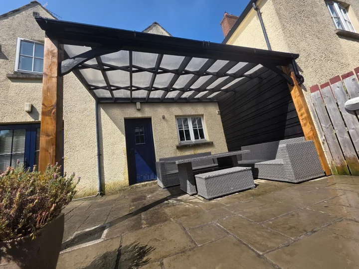 A wide view of the covered seating area beside the house.